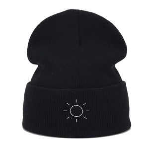 Minimalist black knit beanie with sun embroidery and stylish rolled cuff for winter