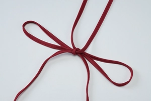 Close-up of red lace-up detail and knit texture on the slim ruffle maxi dress