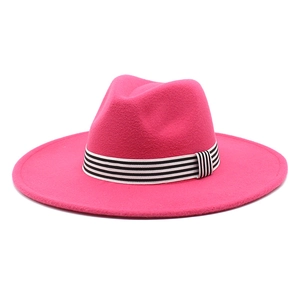 Detail of rose red wool fedora hat featuring a stylish black and white striped ribbon band