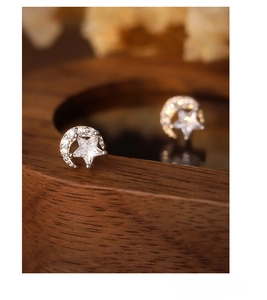 Macro detail of S925 sterling silver moon and star earrings with sparkling zircon stones