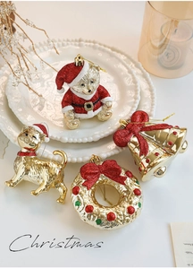 Detail of glittery gold and red Christmas tree ornaments on a white plate with candle decor