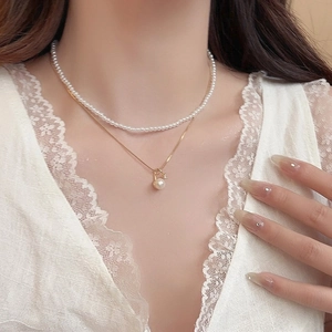 Detailed view of an elegant 18k gold plated double layered pearl and zircon necklace