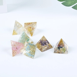 Set of seven mini resin crystal pyramids with gold foil accents on a white background