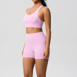 Detail view of pink yoga set showing side pocket on high-waist shorts and ribbed fabric