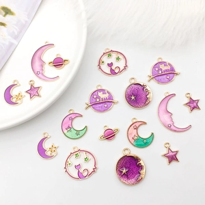 Flat lay of colorful enamel charms featuring moon, stars and cat motifs for DIY jewelry