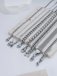 Macro view of various stainless steel chain styles including snake and cuban links