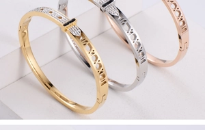 Detailed view of hollowed Roman numeral bracelets set in gold, silver, and rose gold colors