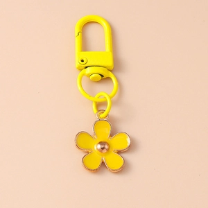 Close-up of a yellow flower keychain with enamel finish and a metal clasp hook