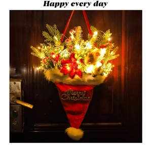 Lighted Christmas hat door hanging with pine needles berries and red poinsettia detail