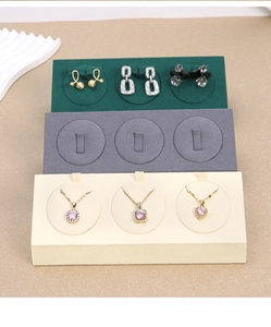 Three-tier jewelry display stand for rings and earrings in green, grey, and beige microfiber