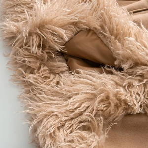 Macro shot of faux fur texture and suede lining on a winter slim coat in camel color