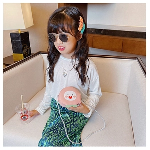 Detail of pink peach-shaped kids crossbody bag with cute cartoon embroidery and rope strap