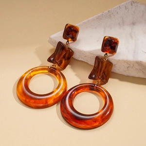 Close-up of vintage geometric amber resin earrings with gold accents and tortoiseshell patterns