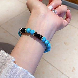 Close-up of blue turquoise and black agate beaded bracelet with gold metal spacers