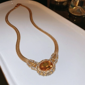 Macro view of gold vintage necklace with amber oval gemstone and sparkling crystals