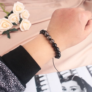 Adjustable beaded bracelet with luminous black beads and glitter details on wrist
