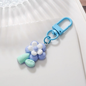 Close-up of purple tulip flower keychain with light blue clasp and green leaf detail