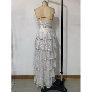 Back view of a white sequined two-piece dress featuring a tiered maxi cake skirt and crop top
