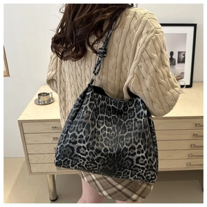 Detail of grey leopard print tote bag with stylish knotted shoulder strap on a model