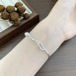 Detail of S925 sterling silver pearl bracelet with fluid irregular design on wrist