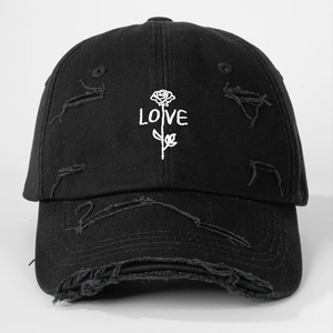 Detailed embroidery of white ROSE and LOVE text on distressed black cotton baseball cap