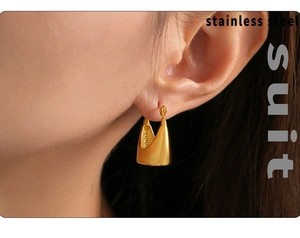 Detail view of 18K gold plated stainless steel teardrop earrings worn by a model