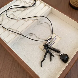 Double-layer vintage heart necklace with black branch pendant and silver beads on a tray