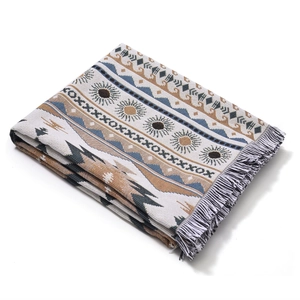 Detail of bohemian geometric cotton blanket with sun motifs and decorative tassels