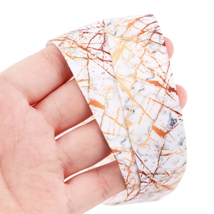 Macro shot of white marble pattern lanyard with gold and dark brown texture details