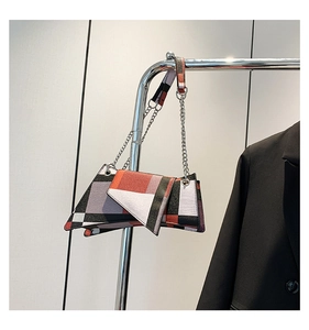 Detail of color-block shoulder bag with geometric patterns and silver chain strap