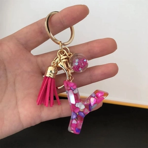 Close-up of pink resin letter Y keychain with heart sequins and star glass ball charm