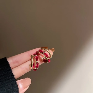 Macro detail of red velvet woven with golden C-shape chain earrings in retro style