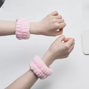 Close-up of pink coral fleece wristbands for washing face to prevent water flow