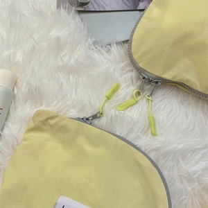 Close-up of yellow waterproof nylon travel organizer bag with smooth gray zipper detail