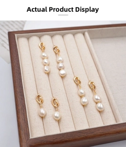 Detail view of pearl earrings set with three designs in a velvet jewelry display box