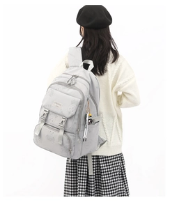 Detail of light gray school backpack with cartoon bear prints and multiple pockets