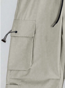 Detail view of cargo pocket with metal grommets and adjustable drawstrings on grey pants
