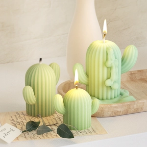 Set di tre candele cactus verde chiaro con trame verticali su un vassoio di legno