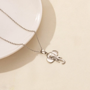 Close-up of polished silver elephant pendant on a fine stainless steel O-chain link