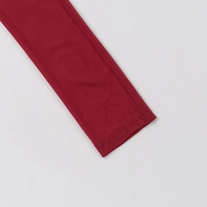 Close-up detail of dark red sheer mesh fabric showing fine mesh texture and cuff stitching