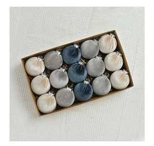 Close-up of 15 flocked velvet Christmas balls in blue, grey and cream in a gift box