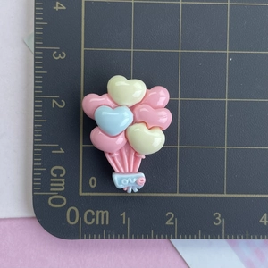 Détails de breloques ballons cœur en résine colorée avec échelle de taille sur tapis