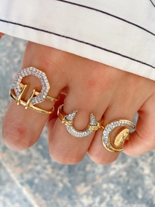 Detailed close-up of mixed gold and silver rings set with zircon on model's hand