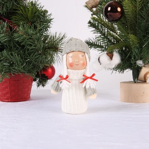 Detail of gray knitted Christmas angel girl doll with red bow on festive tree