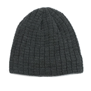 Close-up of thick ribbed knit texture on a dark grey winter beanie for men