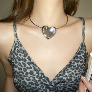 Close-up of a silver 3D heart necklace with a smooth mirror finish on a model