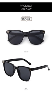 Detail of stylish kids oversized black sunglasses featuring a signature golden D metal logo