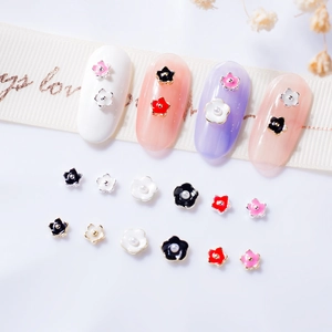 Macro shot of 3D mini five-petal alloy nail art flowers with gold and silver trim