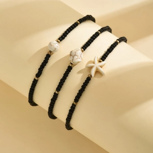 Detail of bohemian 3-piece beaded anklet set with turquoise stones and starfish charm