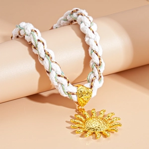 Close-up of a white braided rope necklace with a hammered gold sun pendant for women